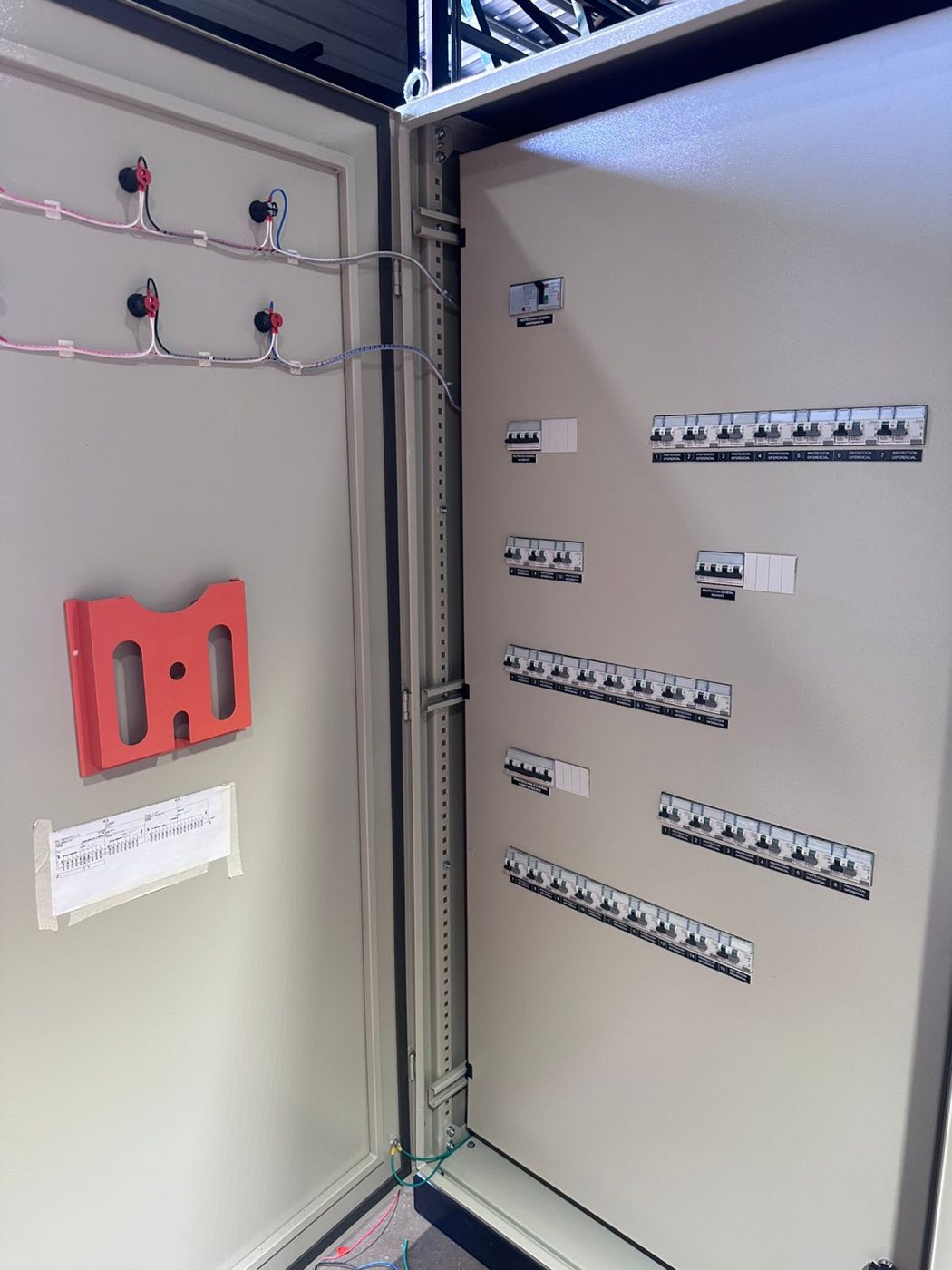 Gabinete metálico de tablero eléctrico Tableros VOLTA con puerta abierta, protecciones rotuladas y plano de circuitos